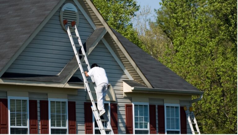 Male Painter climbing a latter to paint a house calling to question if painters should be insured